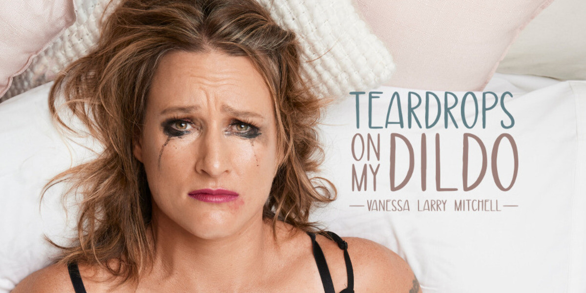 Teardrops on My Dildo–Image is of the artist laying on her back in a bed with a white sheet after her. She has a sad but somewhat comical look on her face. Her make-up is smudged as though she has had a big night.