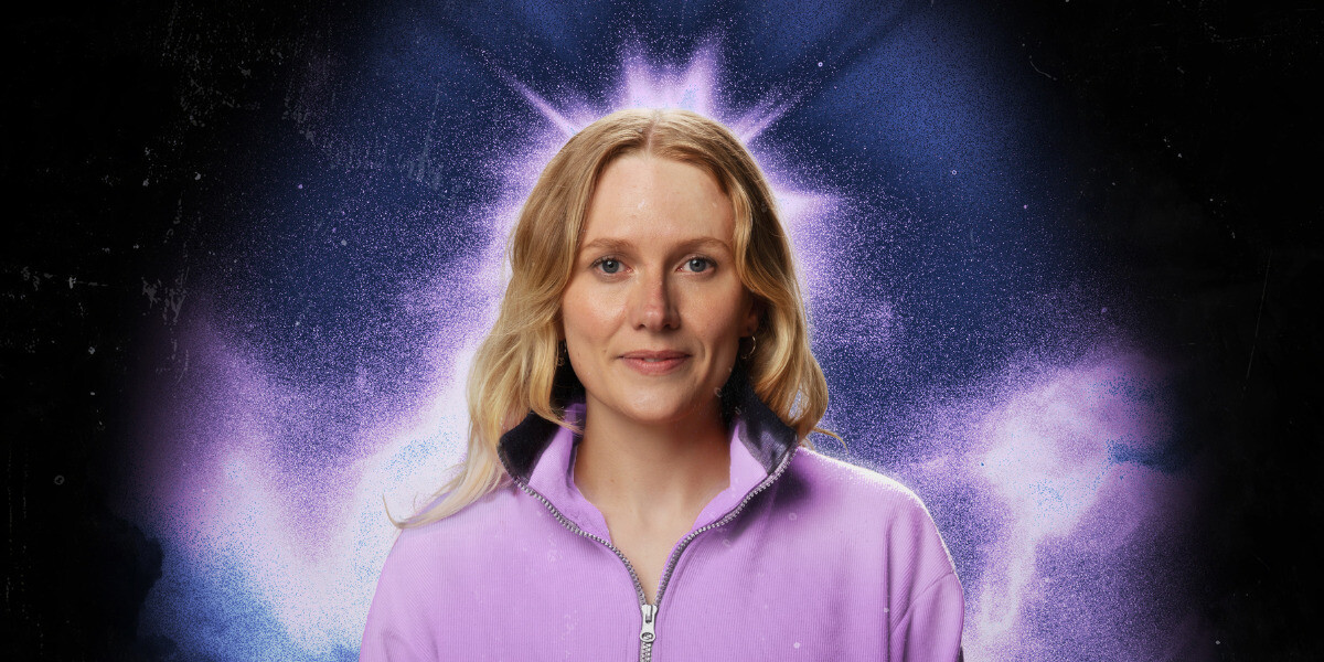 Jordan Barr - Choir Girl–Jordan is in front of a white background, she wears a red jumper and a slight smile.