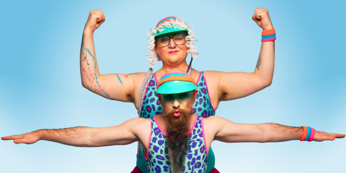 A Tall Nonbinary performer in a frilled bonnet, teal visor and neon leopard print leotard flexes behind a shorter bearded performer in a matching visor and leotard.