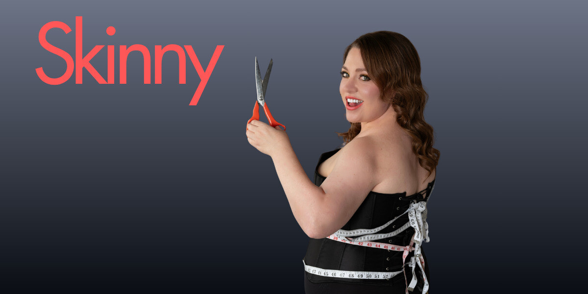 Skinny–Woman in black underwear tied up with tape measures holding orange scissors smiling at the camera