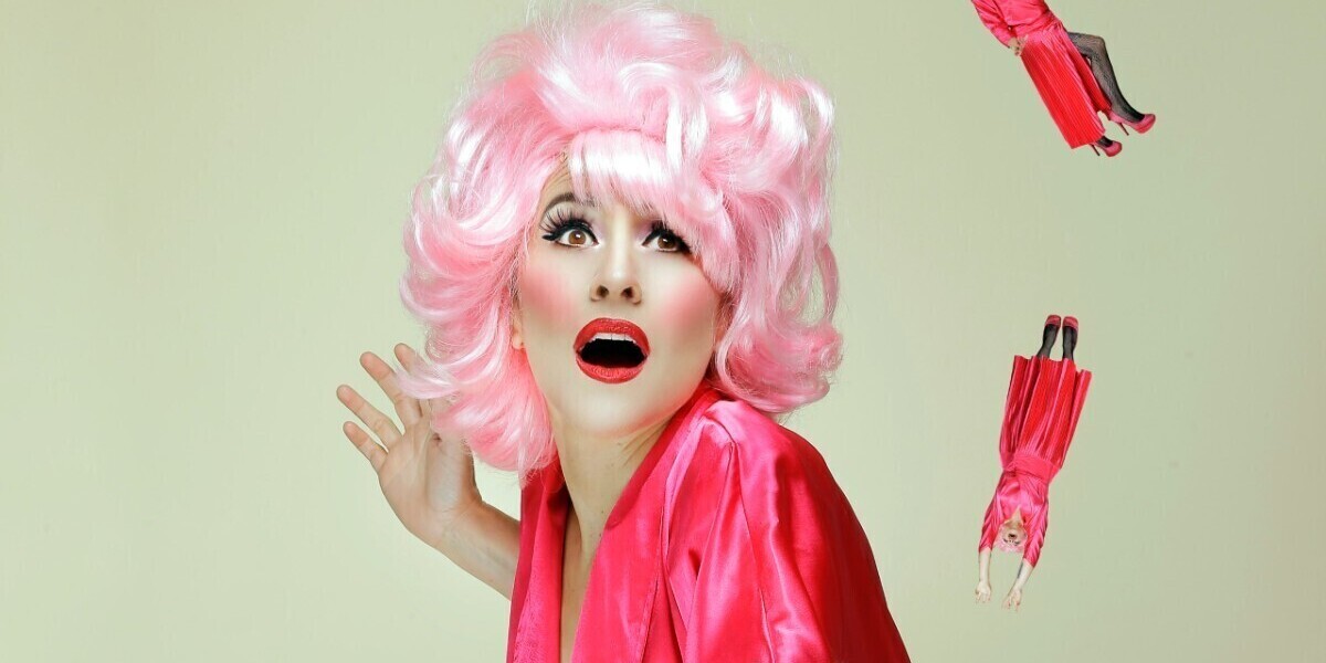 MUAH/Styling and Photography by Rachel Mia
Lucy Best is wearing a pink wig and dress, she looks like she's trying to catch different versions of herself, with a pink baseball mitt. It's very camp.