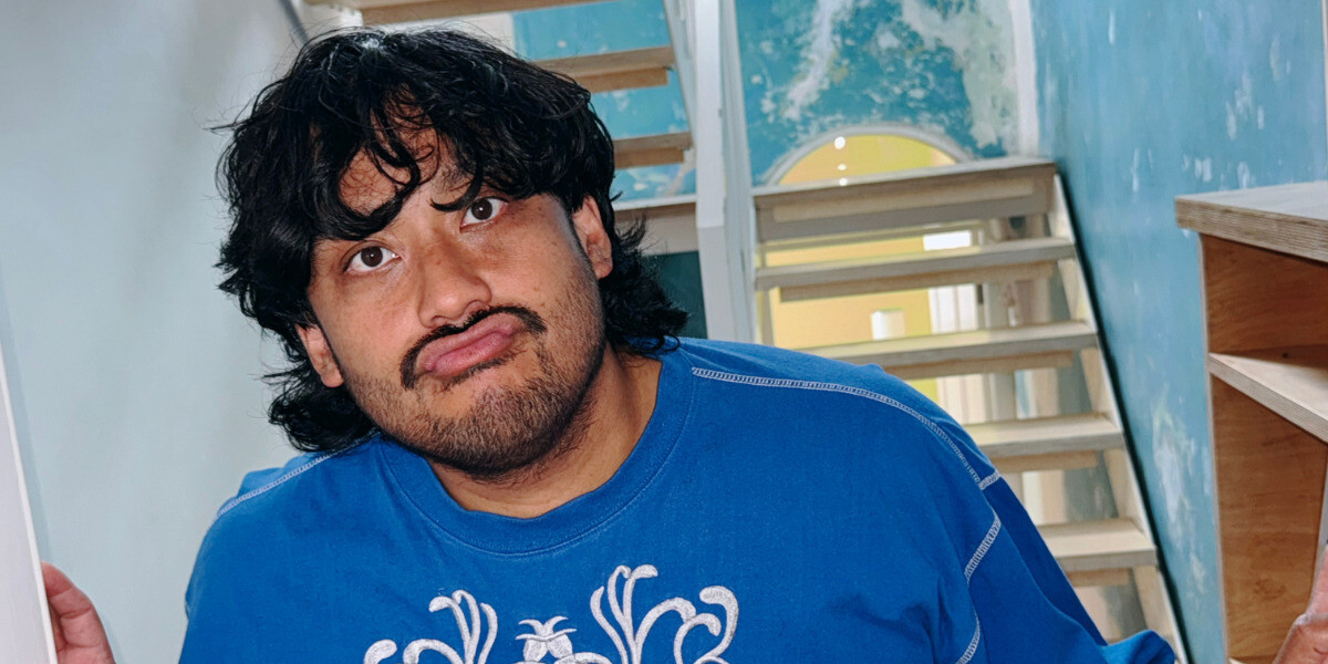 TOUCHING MY ACTIVE MIND - David is wearing a blue t-shirt and leans against a hallway.