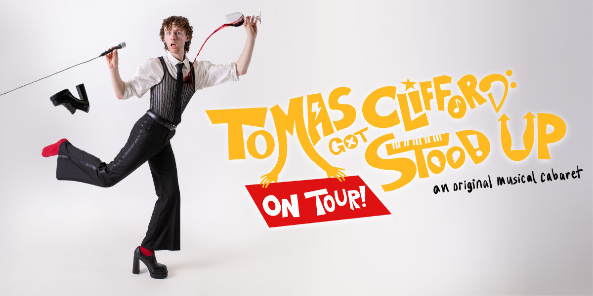 Tomas Clifford Got Stood Up–Tomas in front of a white background with his left foot flung into the air and a high-heel flying off it. Red wine pours from a wine glass in his right hand onto his shirt. His left hand is holding a microphone to his stunned- and confused-looking face. He is standing next to a yellow and red title card that reads "Tomas Clifford Got Stood Up On Tour!"