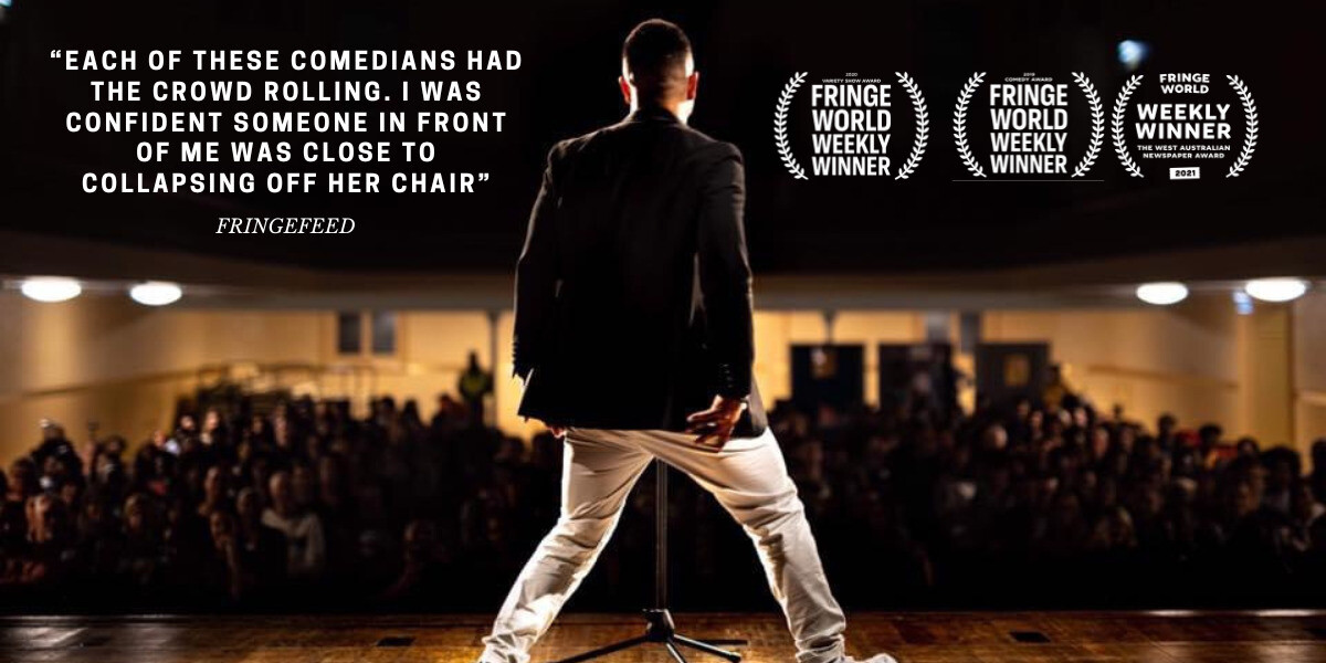 A comedian stands centre stage with his back to the camera, facing a full audience in a theatre. Large text on the left reads: “Each of these comedians had the crowd rolling. I was confident someone in front of me was close to collapsing off her chair” followed by “FringeFeed.” On the right are four Fringe World Weekly Winner laurel badges.
